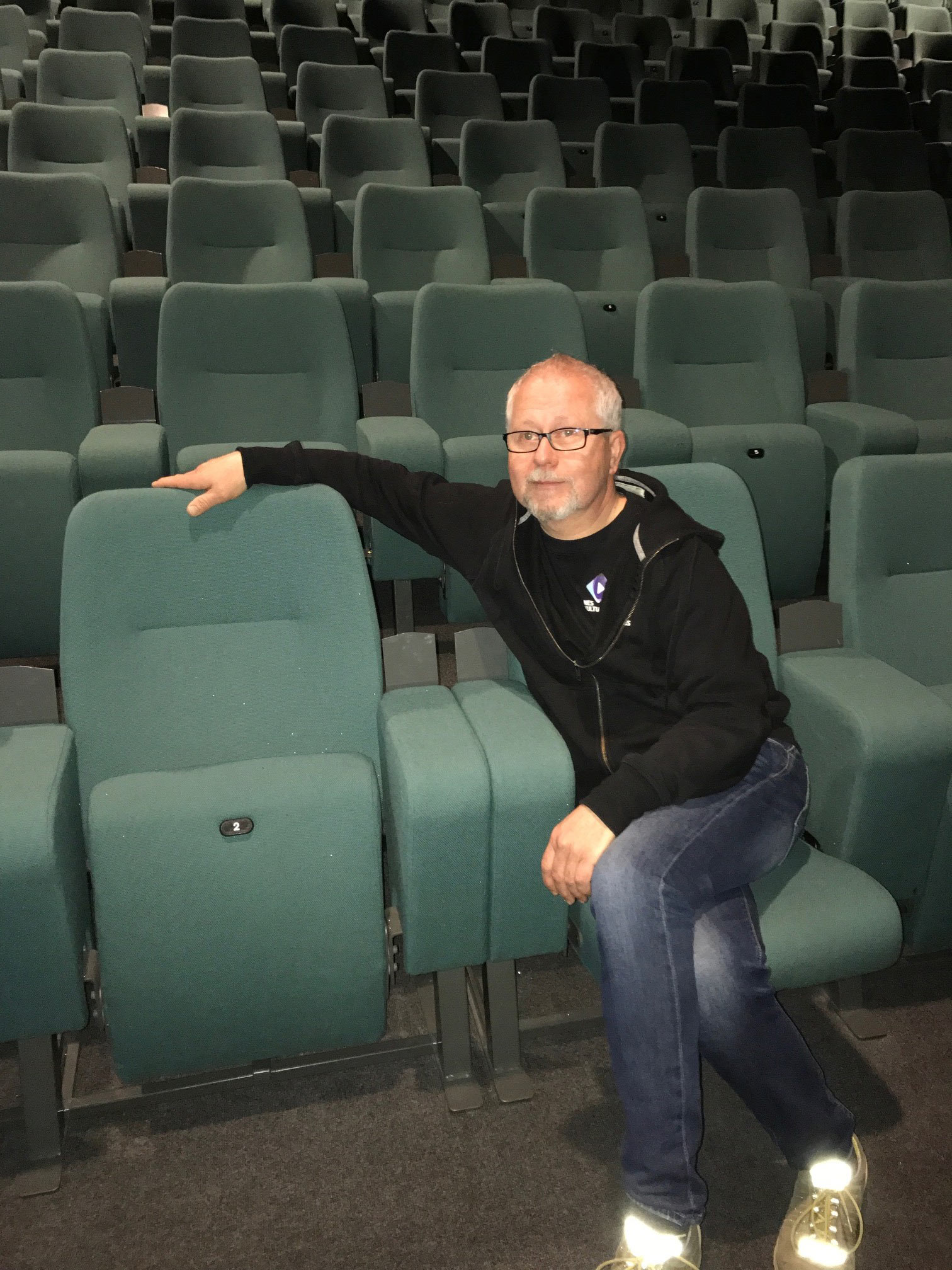 FORBEDRER SEG: Kulturhusleder Jan Magne Hanstad ved Nes kulturhus og Årnes kino inne i salen hvor alle stolene ble trukket om for tre år siden. Stolene er fra Auditoria Services. Foto: Nes kulturhus.